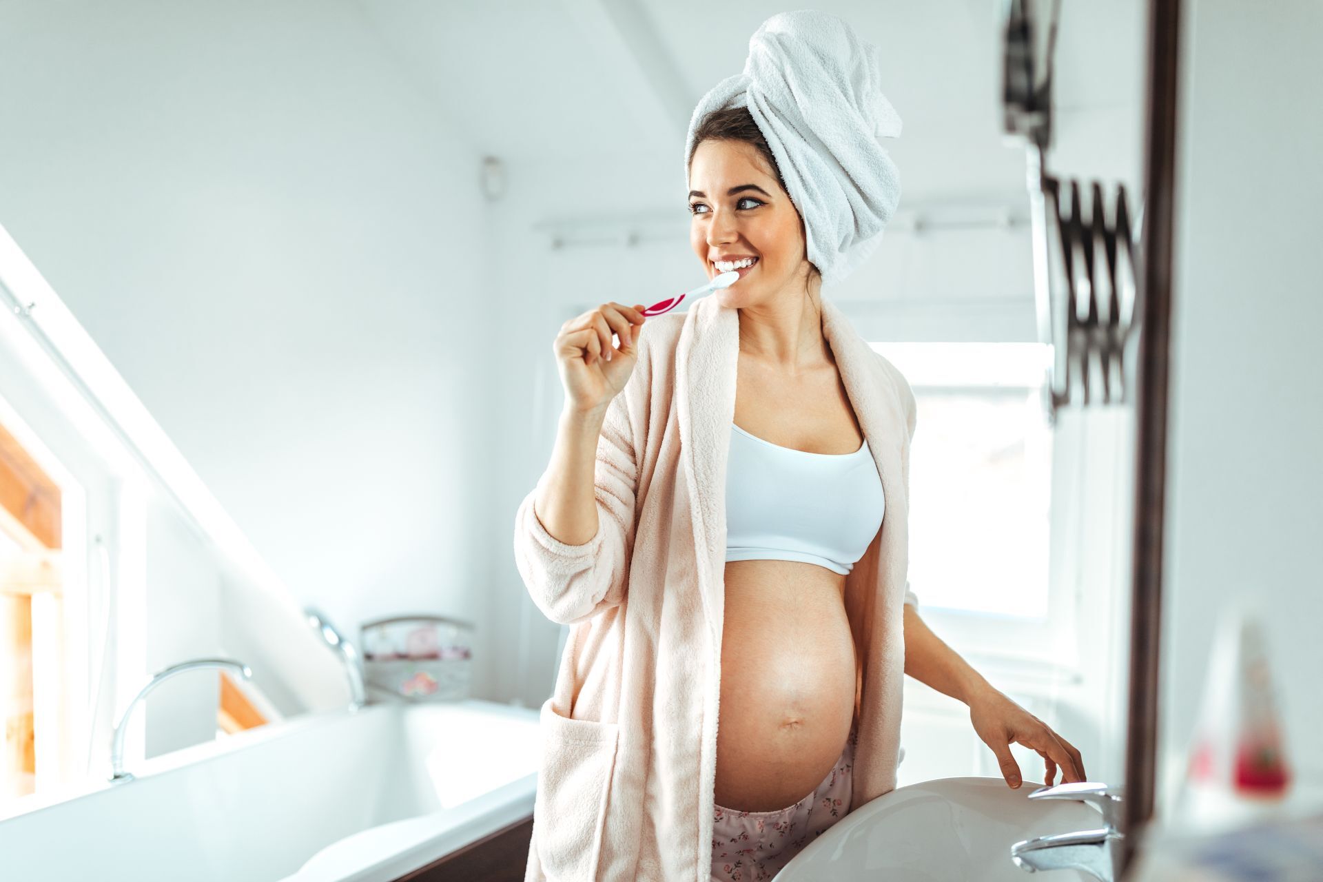 Schwangere Frau putzt sich die Zähne