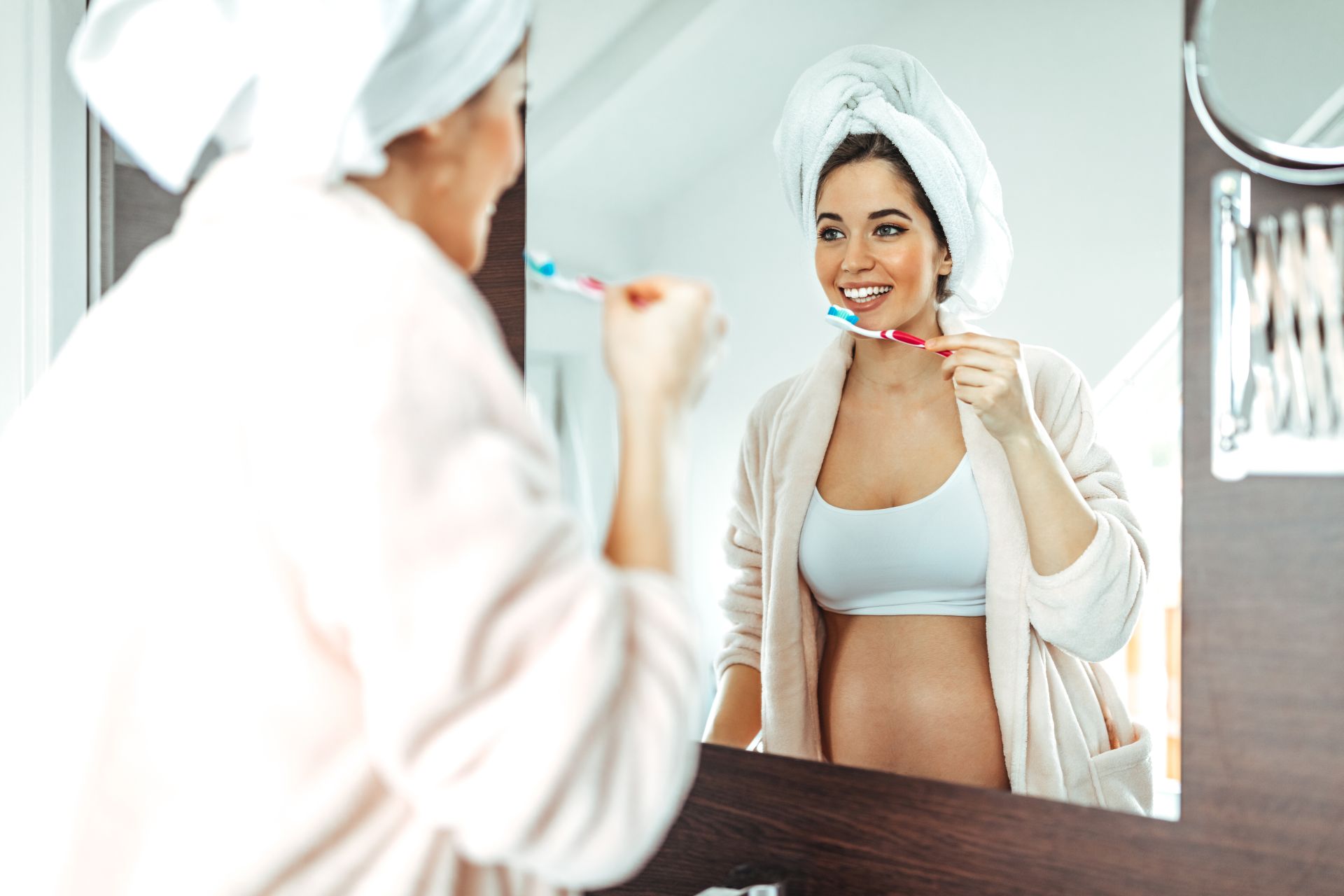 Junge Frau in der Schwangerschaft putzt sich die Zähne 